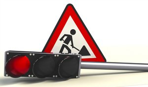 Foto einer liegenden Ampel mit Rotlicht und des Verkehrsschilds "Achtung Baustell"