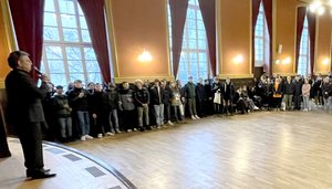 Foto aus dem Blauen Saal mit Bürgermeister Dr. Ruthemeyer, der zu den teilnehmenden Schülerinnen und Schülern spricht. 