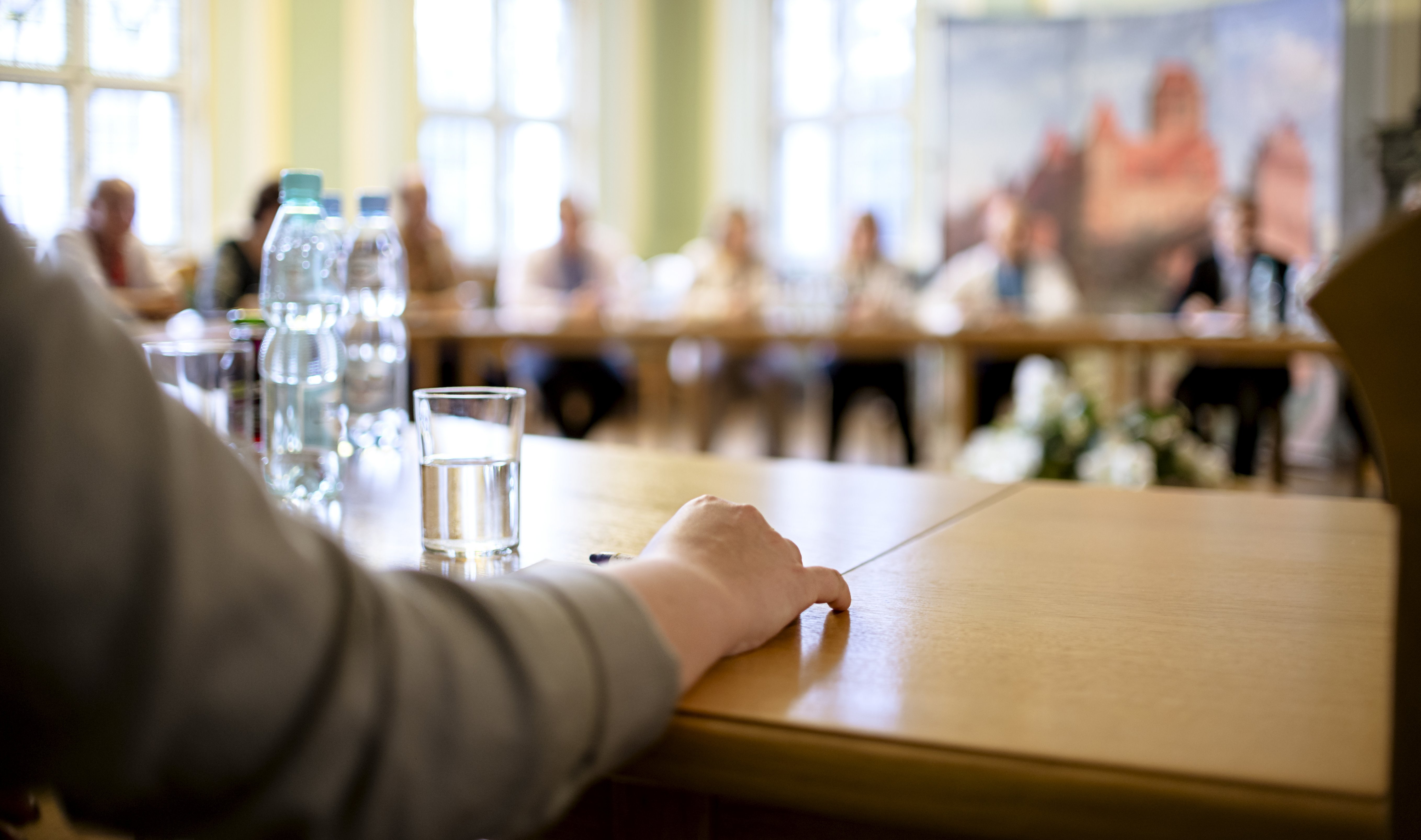 People at a round table discuss different issues. Focus on hand