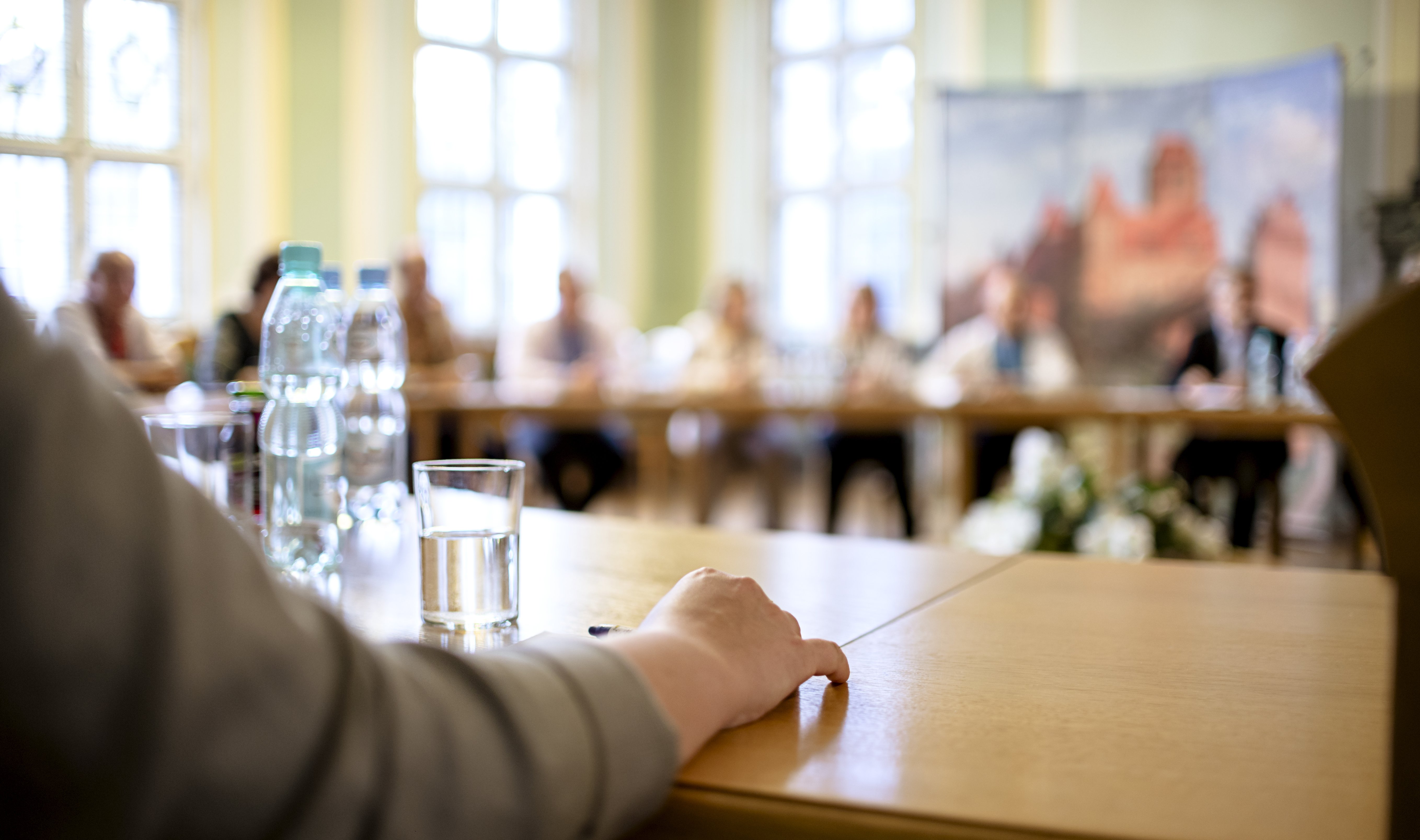 People at a round table discuss different issues. Focus on hand