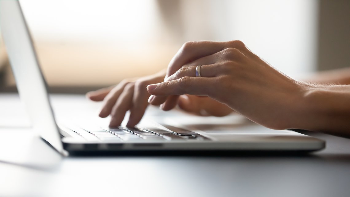 Close up of woman typing message on keyboard