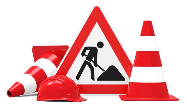 Foto des Schildes "Achtung Baustelle" mit daneben stehendem Absperrhütchen
