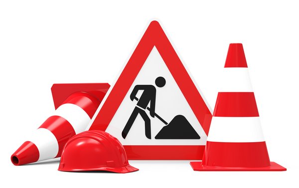 Foto des Schildes "Achtung Baustelle" mit daneben stehendem Absperrhütchen