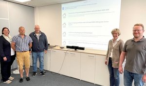 Das beiliegende Foto zeigt vor einem Beamerbild der Website des digitalen Baugenehmigungsverfahrens und das Team der AG Bauordnung