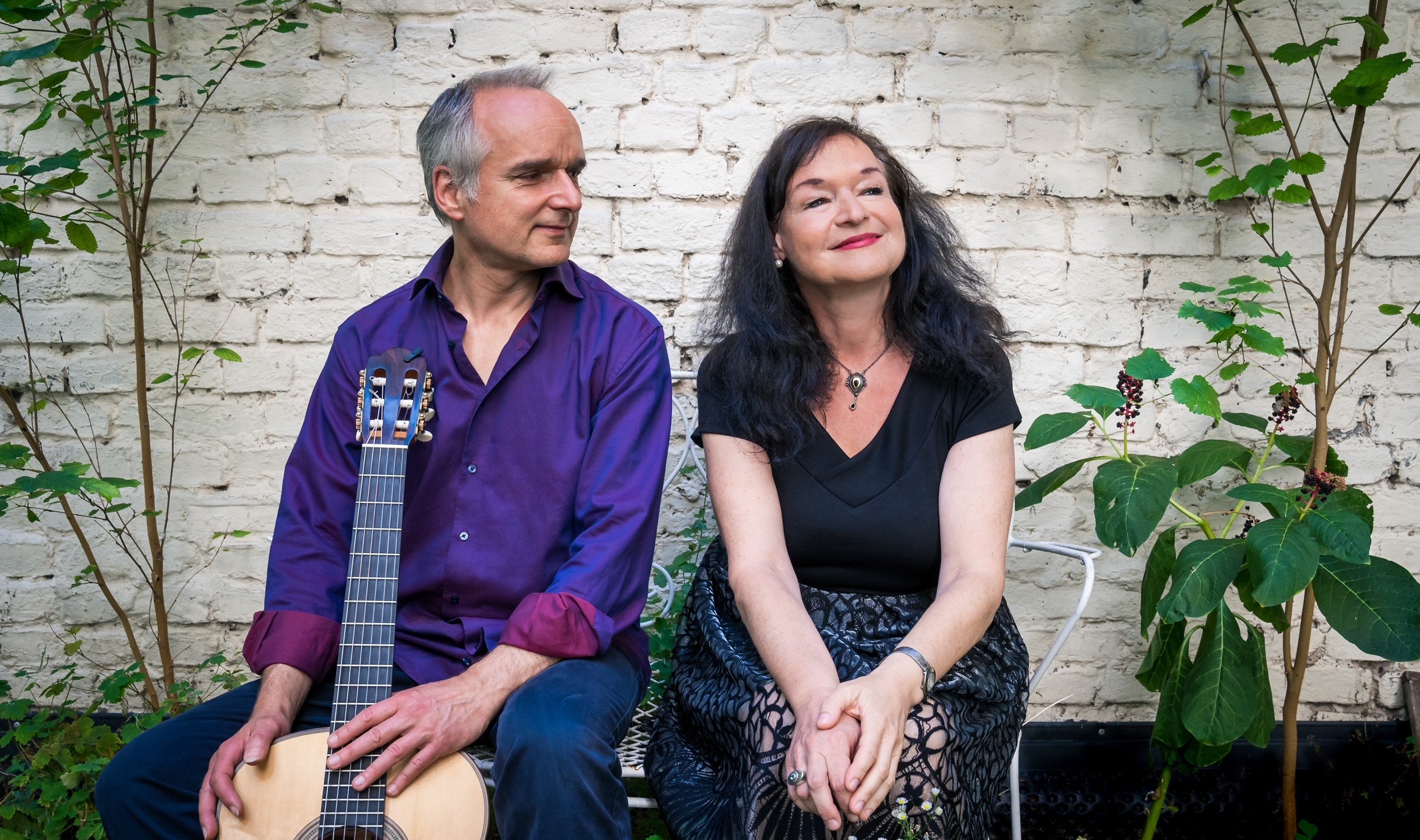 Die Bandmitglieder sitzen auf einer Bank