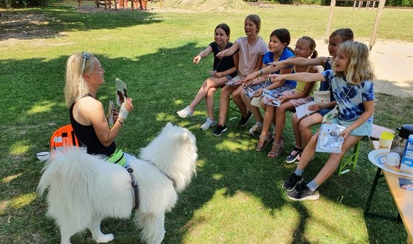 Kinder in der Ferienstadt freuen sich über Besuch von Therapie- und Begleithunden