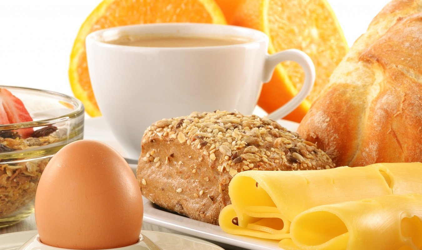 Frühstücksteller mit Brötchen, Ei und Kaffeetasse