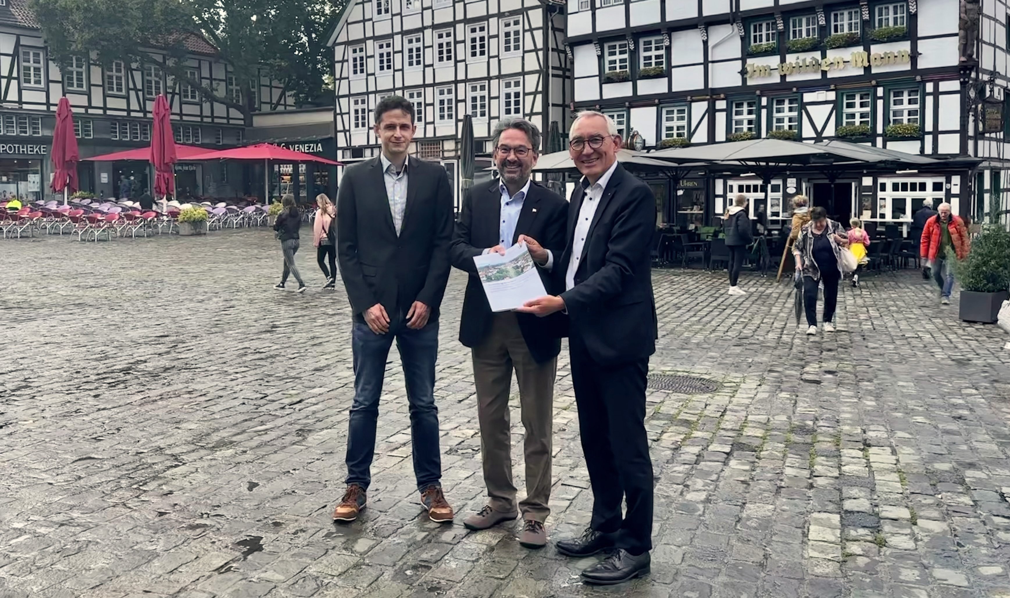 Regierungspräsident Heinrich Böckelühr übergibt zusammen mit Jan Peters (Dezernent Städtebauförderung der BR Arnsberg) den Förderbescheid an Bürgermeister Dr. Eckhard Ruthemeyer