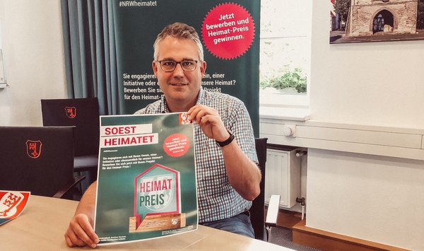 Thomas Gerwin hält Heimatpreis Plakat in der Hand.