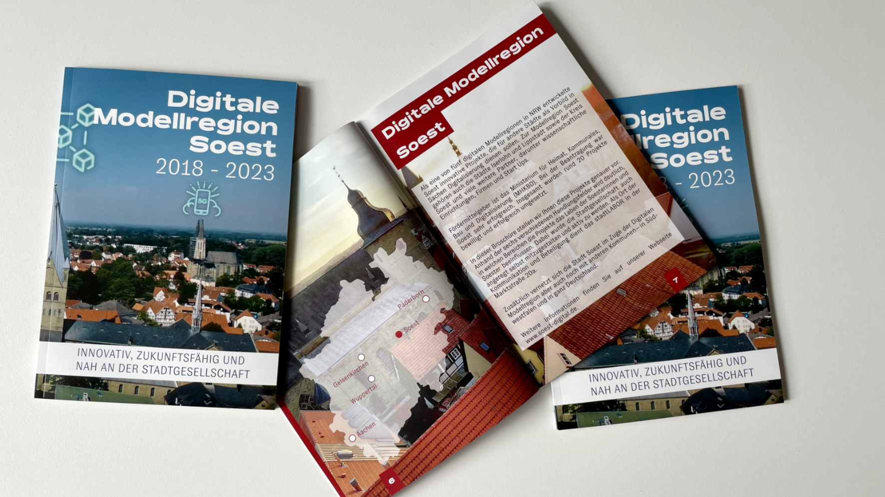 Ein Foto der Abschlussbroschüre, die aufgeschlagen auf einem Tisch liegt.