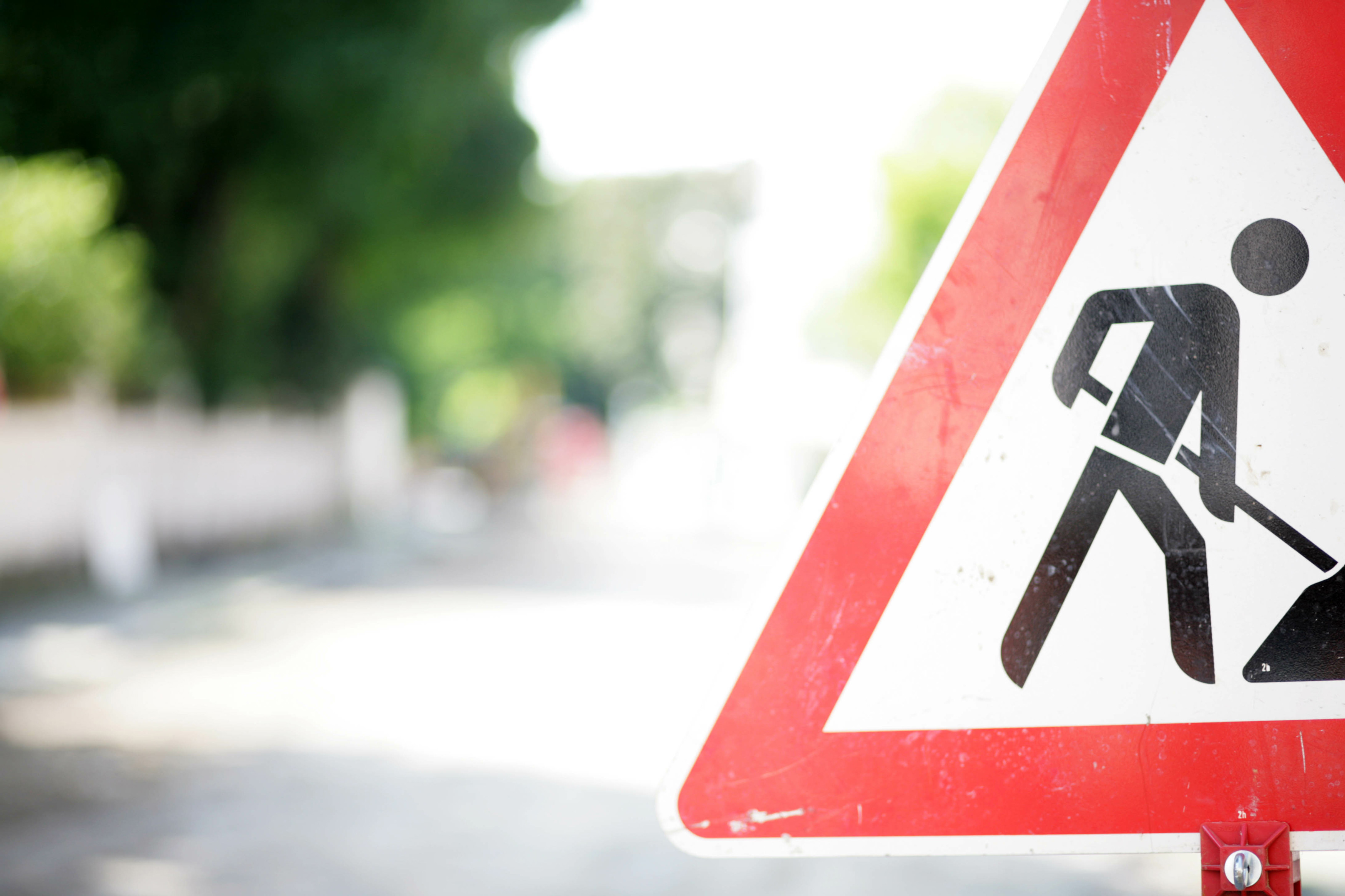 Foto eines Verkehrsschilds "Achtung Baustelle" am Rand einer Straße